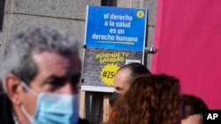 Protesters gather to march to support the public heath service in one of four columns which will meet in the center of Madrid, Spain, Feb. 12, 2023.