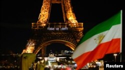 An Iranian national flag is seen as the Eiffel Tower is lit up with the slogan "Women, Life, Liberty" in support of Iranians protesting against their government, in Paris, Jan. 16, 2023. 