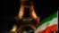 Bendera Iran terlihat berkibar di depan Menara Eiffel di saat menara tersebut menyalakan lampu bertuliskan pesan, "Perempuan, Kehidupan Kebebasan" sebagai bentuk dukungan pada demonstran Iran, di Paris, pada 16 Januari 2023. (Foto: Reuters/Gonzalo Fuentes)