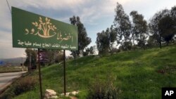 Cagar alam tempat pohon ditanam oleh Green Without Borders di pinggiran selatan kota Nabatiyeh, Lebanon, Senin, 16 Januari 2023. Tulisan Arab di papan itu berbunyi "Hijau Tanpa Batas, panglima syahid cadangan Haji Bassam Tabaja." (AP/Mohammed Zaatari)