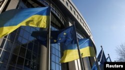 Bendera Uni Eropa dan Ukraina berkibar di luar gedung Parlemen Uni Eropa, di Brussel, Belgia, 28 Februari 2022. (Foto: REUTERS/Yves Herman)