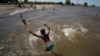 FILE - A boy jumps into the Rio de la Plata during a heat wave in Buenos Aires, Argentina, Jan. 12, 2022. The country is experiencing its worst heat wave in more than six decades, said the National Meteorological Service on Saturday.