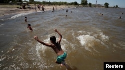FILE - A boy jumps into the Rio de la Plata during a heat wave in Buenos Aires, Argentina, Jan. 12, 2022. The country is experiencing its worst heat wave in more than six decades, said the National Meteorological Service on Saturday.