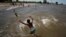 FILE - A boy jumps into the Rio de la Plata during a heat wave in Buenos Aires, Argentina, Jan. 12, 2022. The country is experiencing its worst heat wave in more than six decades, said the National Meteorological Service on Saturday.