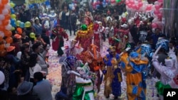Concursantes vestidos como el personaje del Carnaval Pepino muestran movimientos de baile durante una competencia para elegir a los tres personajes principales del Carnaval - Chuta, Pepino y Chola - en La Paz, Bolivia, el viernes 10 de febrero de 2023. El trío de la realeza del Carnaval debe ser experto en contagiar felicidad y no cansarse de bailar. (Foto AP/Juan Karita)