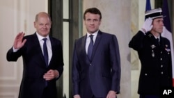 French President Emmanuel Macron, center, welcomes German Chancellor Olaf Scholz, left, Feb. 8, 2023 before a working dinner with Ukrainian President Volodymyr Zelenskyy at the Elysee Palace in Paris.