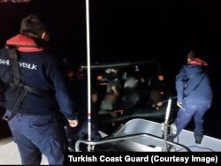 A photo taken by the Turkish coast guard of them rescuing the migrants from the inflatable dinghy that they allege was pushed back into Turkish waters by Greece.
