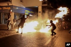 Protesters throw petrol bombs at policemen during an anti-fascist rally, commemorating the killing of Greek rap singer Pavlos Fyssas, in Athens, Sept. 16, 2017.