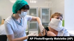 На фото: медпрацівниця в Україні отримує щеплення