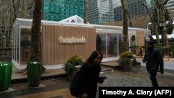 Orang-orang lalu-lalang di sekitar sebuah kios dadakan yang dibuka oleh jaringan media sosial Facebook untuk acara yang berlangsung satu hari pada tanggal 13 Desember 2018 di Bryant Park, New York (foto: Timothy A. Clary/AFP)