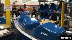 Painted wheelbarrow buckets arrive at the end of the assembly line at the AMES Companies factory, the largest wheelbarrow factory in the world, in Harrisburg, Pennsylvania, June 29, 2017. 