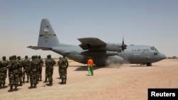 FILE - A C-130 U.S. Air Force plane taxis as Nigerien soldiers stand in formation during the Flintlock 2014 military exercise in Diffa, Niger, March 8, 2014. 
