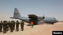 Un avion C-130 de la 'United States Air Force' prêt au décollage, alors que des soldats nigériens s’apprêtent à participer à un exercice militaire à Diffa (Niger), le 8 mars 2014.