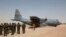 FILE - A C-130 U.S. Air Force plane taxis as Nigerien soldiers stand in formation during a military exercise in Diffa, Niger, March 8, 2014. 
