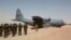 FILE - A C-130 U.S. Air Force plane taxis as Nigerien soldiers stand in formation during the Flintlock 2014 military exercise in Diffa, Niger, March 8, 2014. 