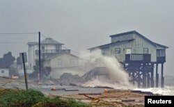 Waves crash on stilt houses along the shore as Hurricane Michael's power is unleashed in Alligator Point, Franklin County, Fla., Oct. 10, 2018.