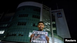 El fotógrafo Harry Long, del desaparecido periódico Apple News, muestra la primera plana de la última tirada frente a la sede del diario en Hong Kong el 24 de junio de 2021.