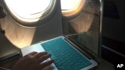 Seorang penumpang menggunakan laptopnya dalam penerbangan ke Atlanta dari Boston, 1 Juli 2017. (Foto: dok). 