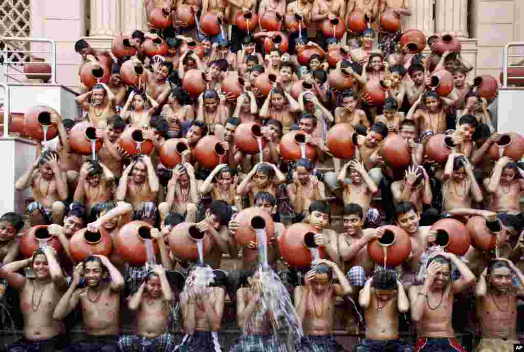 Indian students pour water on each other as part of a ritual bath on the eve of Magh Purnima in Ahmadabad. Many Hindu devotees take a holy bath during the auspicious festival hoping that their sins are washed away according to ancient Hindu tradition.