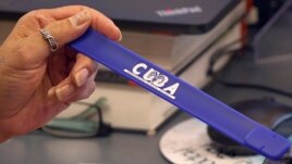Veronica Madrid, administrative assistant at Cuba High School shows a slap bracelet USB drive loaded with assignments Oct. 19, 2020, outside Cuba, New Mexico.