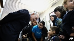 BM Çocuk Fonu (UNICEF) Başkanı Anthony Lake, Şam dışında bir sağlık merkezinde aşı yaptırmaya giden çocuklarla konuşurken