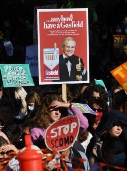 Seorang siswa sekolah memegang plakat dalam aksi "School Strike 4 Climate" di Melbourne, 21 Mei 2021. (Foto: William WEST / AFP)