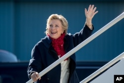 Democratic presidential candidate Hillary Clinton waves to members of the media as she boards her campaign plane at Westchester County Airport in White Plains, New York, Nov. 1, 2016, to travel to Florida for rallies.