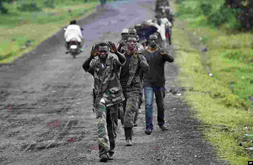 A column of Congolese M23 rebels motion to the photographer not to take pictures on the Goma to Rushuru road, north of Goma, November 27, 2012.