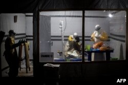 FILE - Health workers treat an unconfirmed Ebola patient inside an Ebola Treatment Center (ETC) in Butembo, Democratic Republic of the Congo, Nov. 3, 2018.
