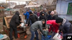 People line up to get water at a well on the outskirts of Mariupol, Ukraine, March 9, 2022.