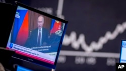 FILE - Russian President Vladimir Putin appears on a television screen at the stock market in Frankfurt, Germany, Feb. 25, 2022.