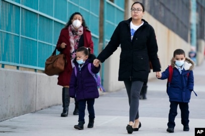 Anak-anak dan pengasuh mereka tiba di sekolah di New York, Senin, 7 Maret 2022. (AP/Seth Wenig)