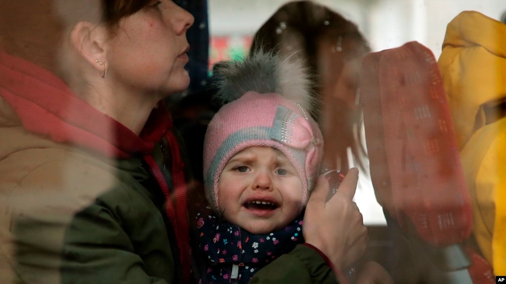 A Ukrainian child reacts as he boards a bus after arriving at Hendaye train station, southwestern France, Wednesday, March 9, 2022. (AP Photo/Bob Edme)