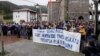 FILE - People stand behind a banner reading "Freedom for our neighbor Pablo Gonzalez. Press Freedom," during a demonstration, after Gonzalez was detained by Polish authorities on espionage charges, in Nabarniz, Spain, March 6, 2022.