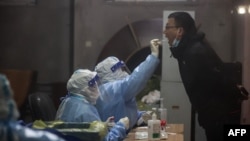 A resident undergoes a nucleic acid test for COVID-19, in Changchun in China's northeastern Jilin province, March 11, 2022. 