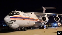FILE - In this photo provided by Russian Emergency Situations Ministry press service, boxes of Russian aid supplies arrive on a Russian cargo plane after a massive explosion at the port, in Beirut, Lebanon, Aug. 5, 2020.