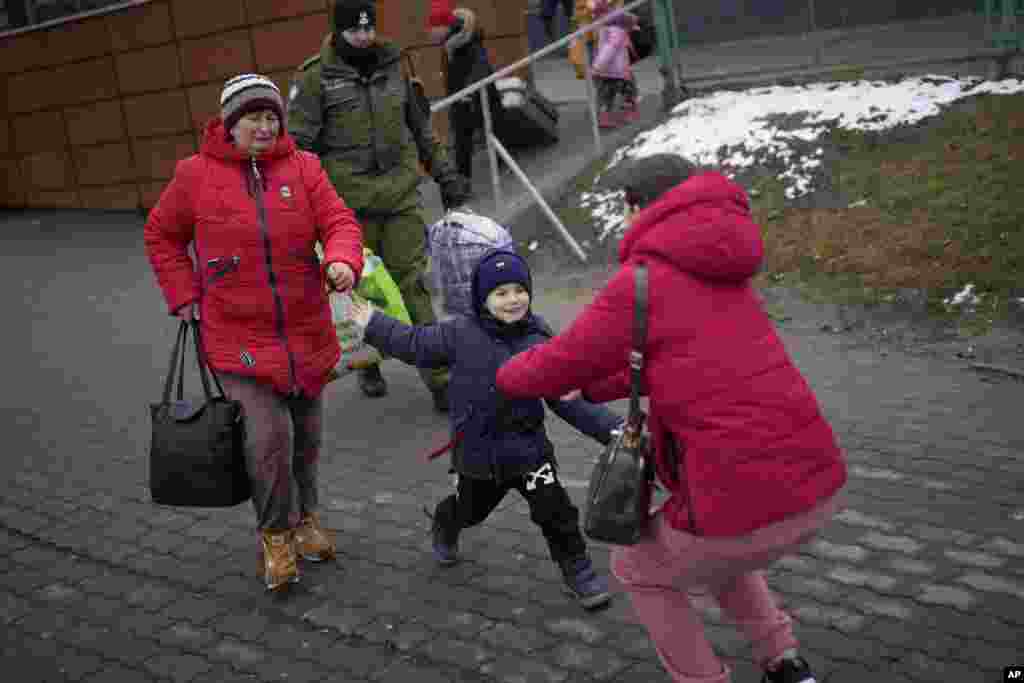 Ina Karpanko, who lives in Poland, right, reunites with her son Vanya and his grandmother, who are fleeing the war in neighboring Ukraine, at the Medyka border crossing in Poland. (AP Photo/Daniel Cole)