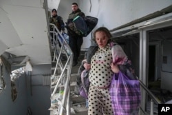 Arhiva - Trudnica, koja je kasnije identifikovana kao Marijana Višegirskaj, silazi niz stepenice porodilišta oćtećenog u ruskom vazdušnom udaru, u Mariupolju, Ukrajina, 9. marta 2022.