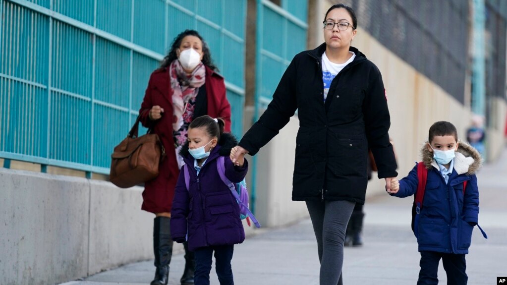 Children and their caregivers arrive for school in New York, Monday, March 7, 2022. (AP Photo/Seth Wenig)