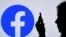 En esta ilustración de fotografía de archivo, una persona mira un teléfono inteligente con el logotipo de la aplicación de Facebook en el fondo, el 17 de agosto de 2021, en Arlington, Virginia.