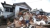 Resident Ken Bridge stands on a pile of his flood-damaged furniture outside his home in Lismore, Australia, March 9, 2022. 