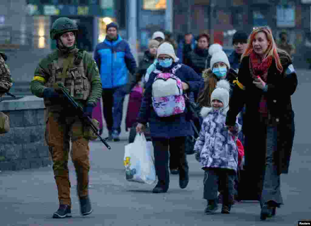 Un militar escolta a personas con niños desde el Hospital Infantil Central de Kiev hasta un tren de evacuación de Kiev a Lviv, el 7 de marzo de 2022.