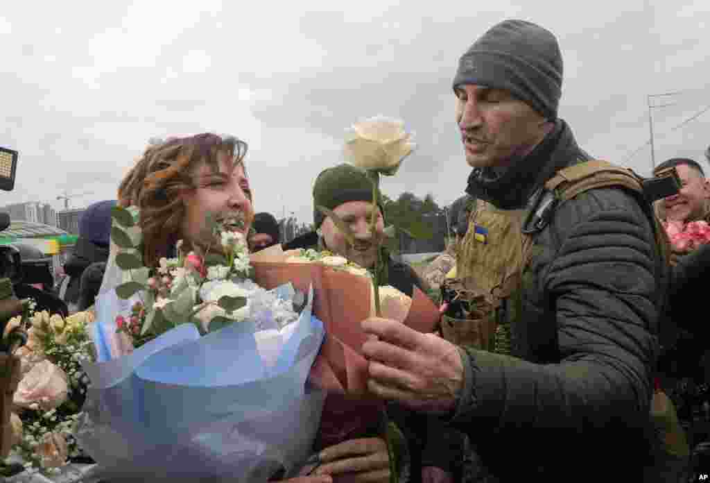 Kyiv mayor and former Ukrainian heavyweight boxing world champion Wladimir Klitschko, right, congratulates newly married members of the Ukrainian Territorial Defense Forces Lesia Ivashchenko, left, and Valerii Fylymonov, after a wedding ceremony at a checkpoint in Kyiv.
