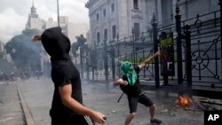Manifestantes lanzan piedras durante una protesta frente al Congreso mientras los legisladores se preparan para votar una ley para ratificar el acuerdo del gobierno con el Fondo Monetario Internacional, en Buenos Aires, Argentina, el jueves 10 de marzo de 2022.