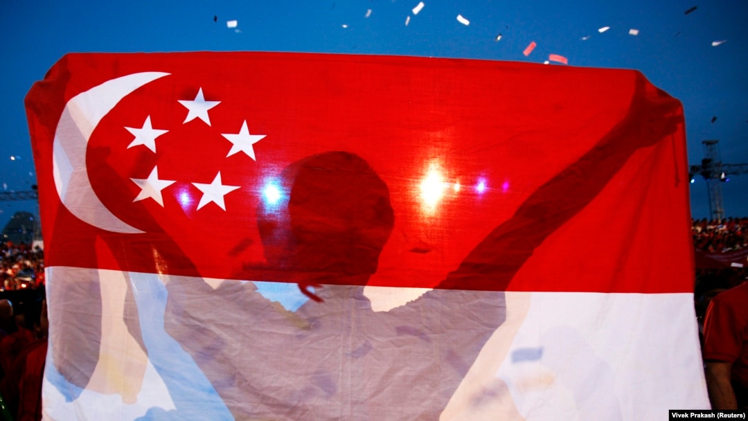 Seorang pria membawa bendera Singapura. Singapura meminta Kedutaan Besar Israel di negara kota tersebut menghapus postingan media sosial yang dinilai “rawan”. (Foto: REUTERS/Vivek Prakash)