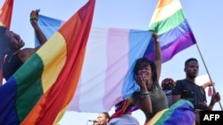 FILE - Dozens of people cheer and dance as they take part in the Namibian Lesbians, Gay, Bisexual and Transexual (LGBT) community pride Parade in the streets of the Namibian capital on July 29, 2017 in Windhoek. 