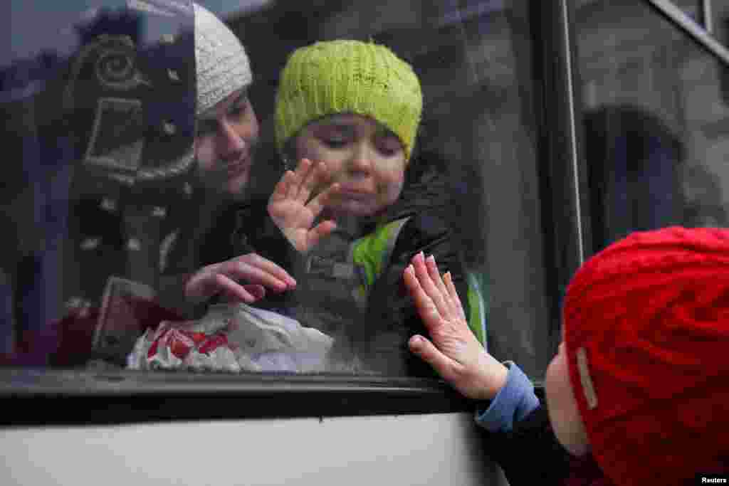 Alexandra, 12, holds her sister Esyea, 6, who cries as she waves at her mother Irina, while members of the Jewish community of Odessa board a bus to flee Russia&#39;s invasion of Ukraine, in Odessa, Ukraine.