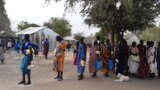 FILE - Displaced people in the town of Bor, South Sudan, collect food aid in February 2022. (Kate Bartlett/VOA)