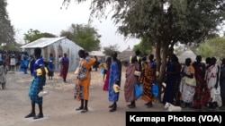 FILE - Displaced people in the town of Bor, South Sudan, collect food aid in February 2022. (Kate Bartlett/VOA)