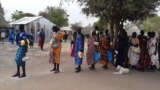 FILE - Displaced people in the town of Bor, South Sudan, queue to collect food aid. (Kate Bartlett/VOA)